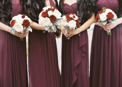 Bridesmaids in burgundy dresses with red and white rose bouquets | The Ivy Lea Club | AMBPhoto